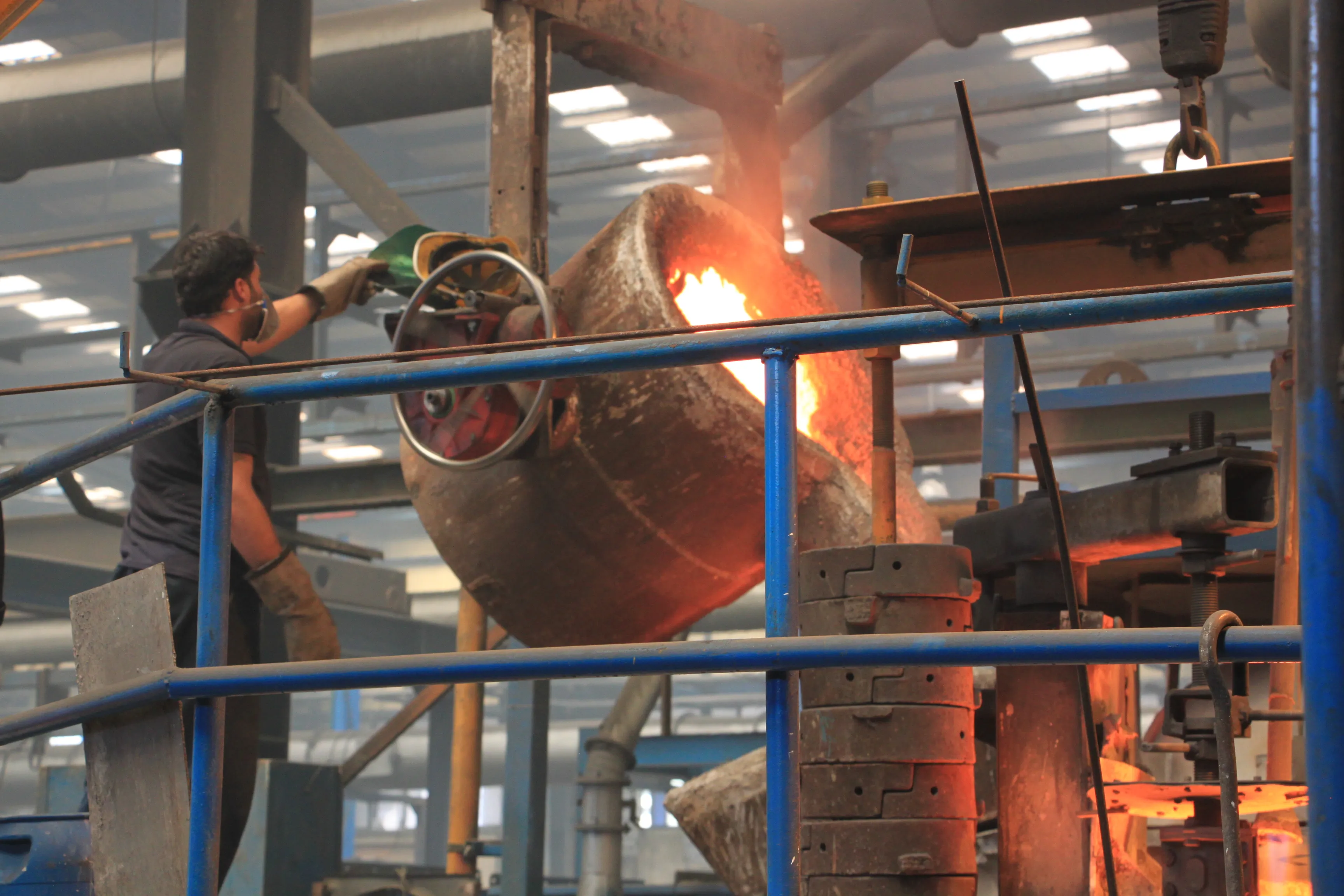 Worker pouring molten iron from a ladle in the FDG foundry
