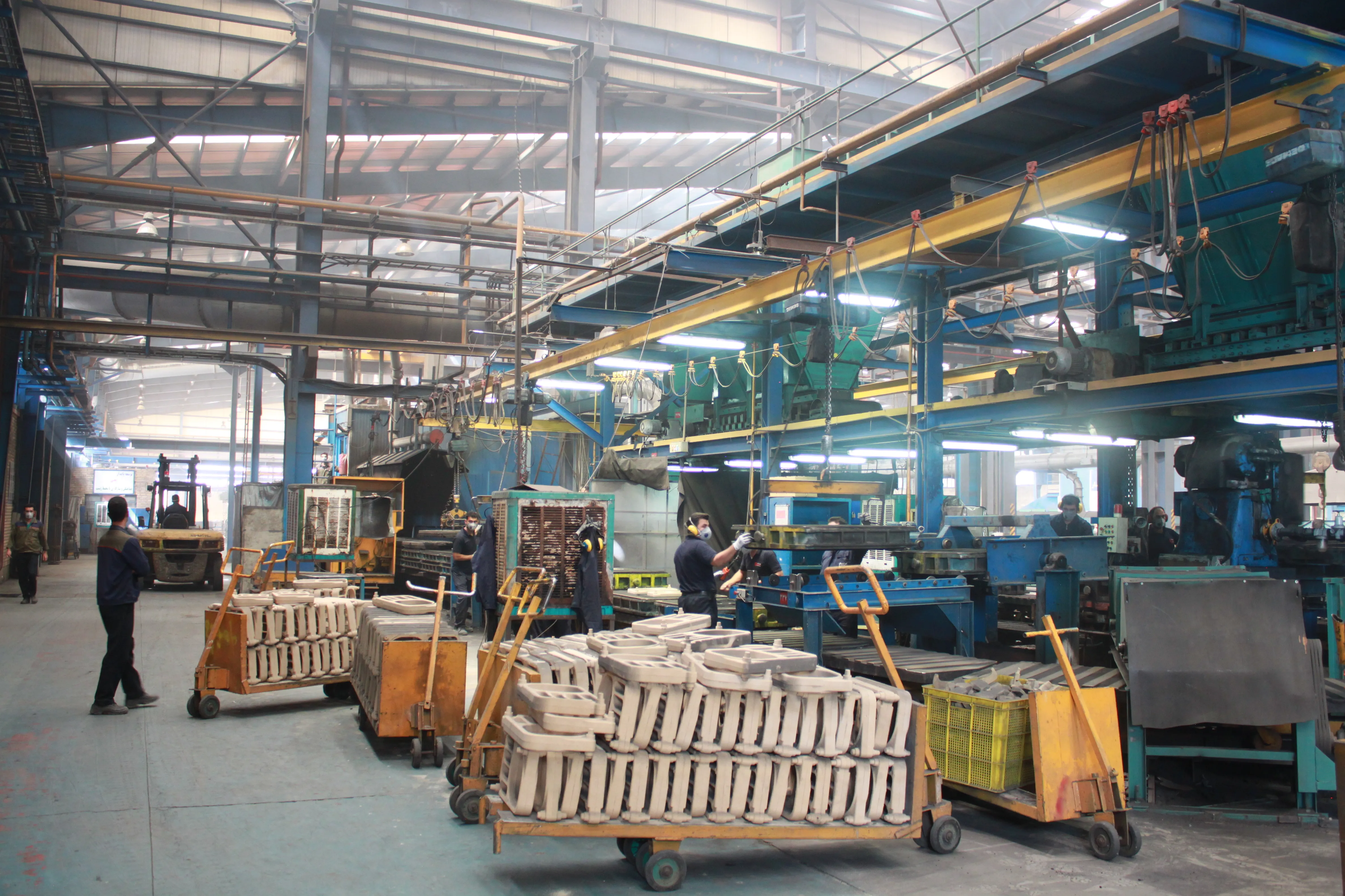 Casting production floor with mould carts and workers